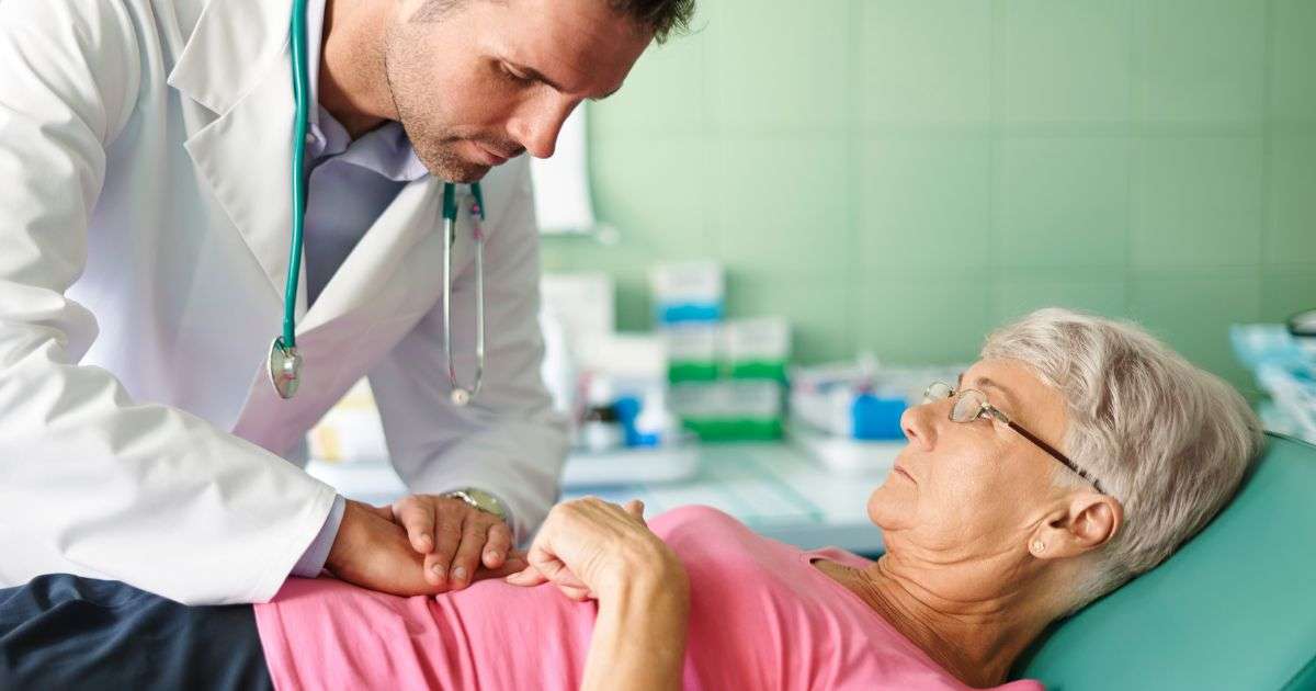 Médico examinando o abdômen de paciente durante consulta, representando o diagnóstico da síndrome do intestino irritável.
