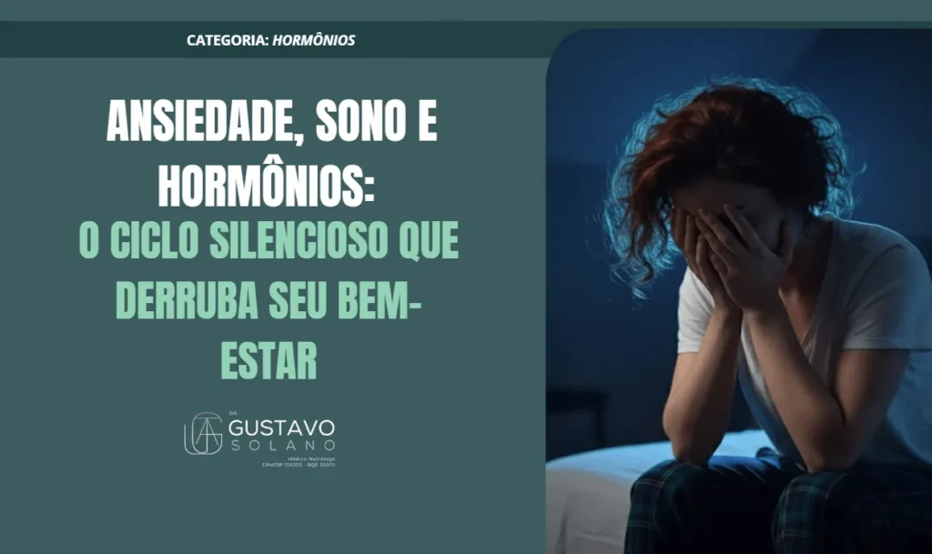 Mulher sentada na cama durante a noite, com as mãos no rosto, demonstrando exaustão e ansiedade. Imagem utilizada em artigo sobre a relação entre ansiedade, sono e desequilíbrios hormonais.